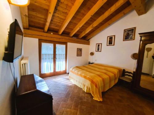 a bedroom with a bed and a flat screen tv at Villadina Farm in Colico