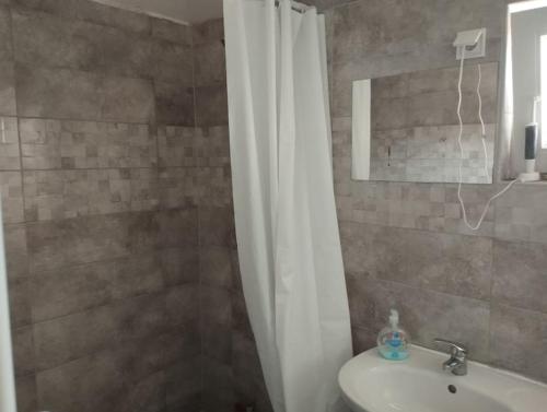 デブレツェンにあるIbolya Apartman Debrecen kertvárosàbanのシャワーカーテンと洗面台付きのバスルーム