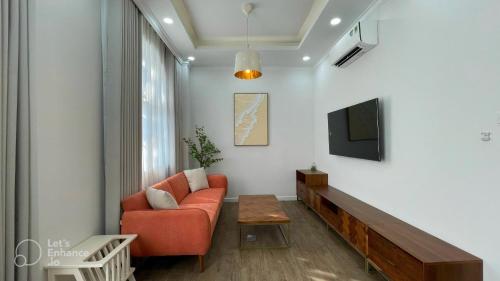 a living room with a couch and a tv at Holiday Villa Novaworld Phan Thiet in Phan Thiet