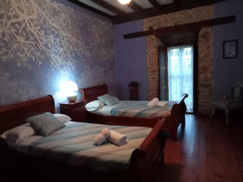 a bedroom with two beds and a window in it at Palacio de Cantiz "Reserva de Ancares" in Becerreá