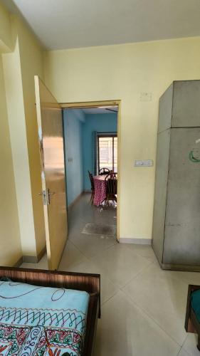 Zimmer mit einem Bett und einem Zimmer mit einem Tisch in der Unterkunft SheStay - Homestay by Women, for Women in Thākurdwari