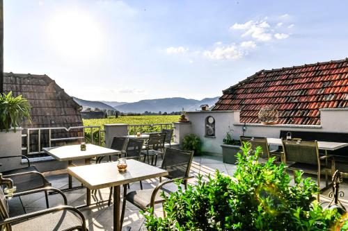 a patio with tables and chairs on a balcony at Winzerhof Mörtinger in Dürnstein
