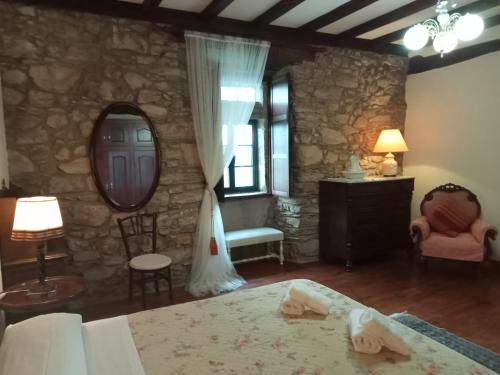 a bedroom with a bed and a stone wall at Palacio de Cantiz "Reserva de Ancares" in Becerreá