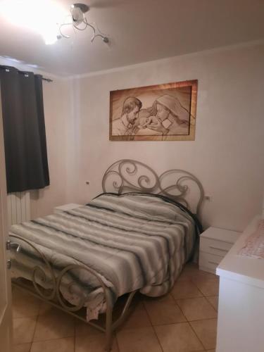 Ce lit se trouve dans une chambre ornée d'une peinture murale. dans l'établissement Villa Anna, à Massarosa