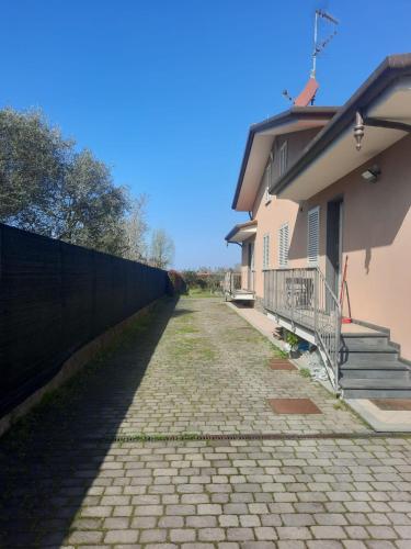 une route en briques à côté d'une maison avec une clôture dans l'établissement Villa Anna, à Massarosa