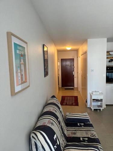 a living room with a couch against a wall at Face à la mer studio de 33m2 avec terrasse et wifi in Larmor-Plage