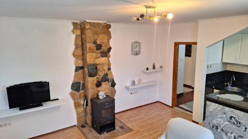 a living room with a stone fireplace and a television at Apartman Porfido in Mostar