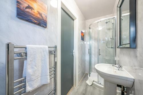 a white bathroom with a sink and a shower at *RA246* For your most relaxed & Cosy stay + Free Parking + Free Fast WiFi * in Knowsthorpe