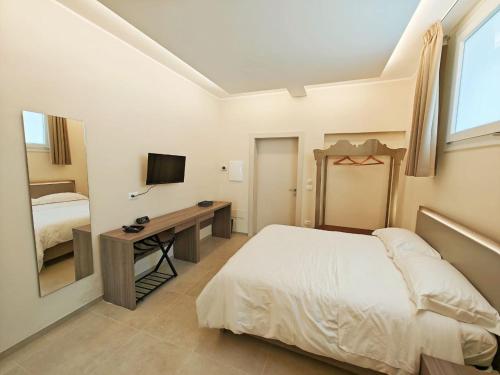 a bedroom with a bed and a desk with a television at A casa di Nina in Leverano