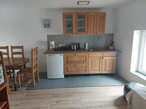 a kitchen with wooden cabinets and a table and a sink at Gite de Moulin Maurt in Xertigny