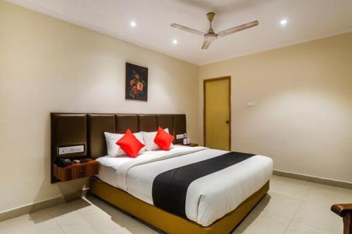 a bedroom with a large bed with red pillows at Blossoms Hotel & Service Apartments in Chennai