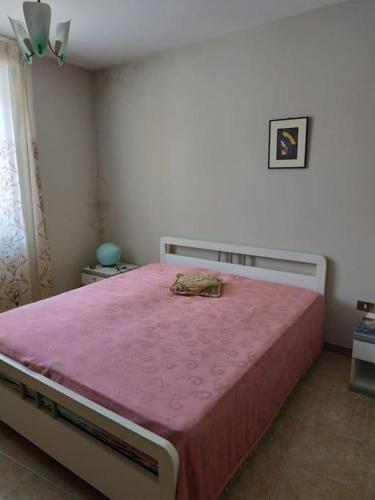 um quarto com uma cama grande e um cobertor rosa em Casa Isabella Napoli em Montegiordano