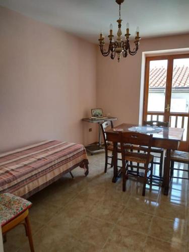 a dining room with a table and chairs and a bench at Casa Isabella Napoli in Montegiordano