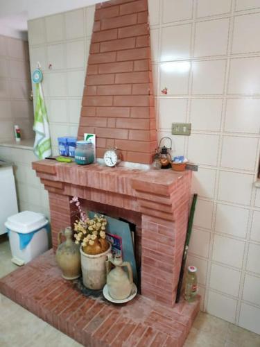 a brick fireplace in a living room with a clock at Casa Isabella Napoli in Montegiordano