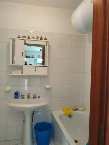 uma casa de banho com um lavatório, um espelho e uma banheira em Casa Isabella Napoli em Montegiordano