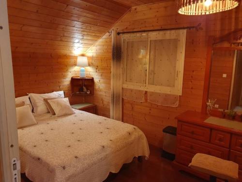 sypialnia z łóżkiem w drewnianym domku w obiekcie Chalet Chaleureux w mieście La Plaine-des-Palmistes