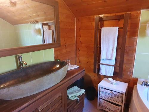 a bathroom with a large sink in a log cabin at Chalet Chaleureux in La Plaine des Palmistes