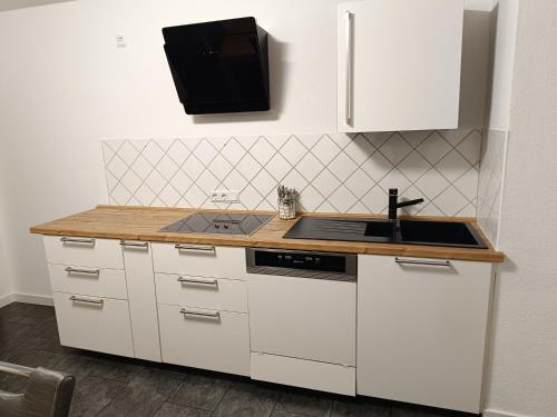 a kitchen with white cabinets and a sink at Ferienwohnung Schneider in Bad Wildungen