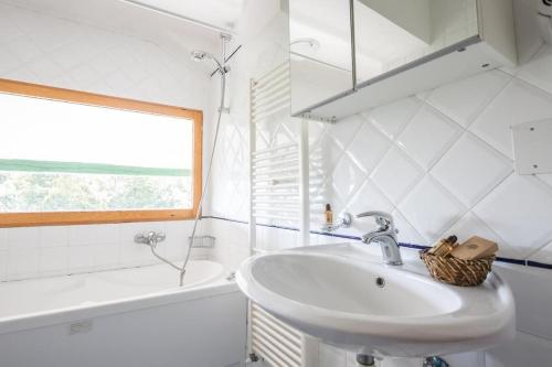 a white bathroom with a sink and a bath tub at Hotel Tre Cime Terminillo in Terminillo