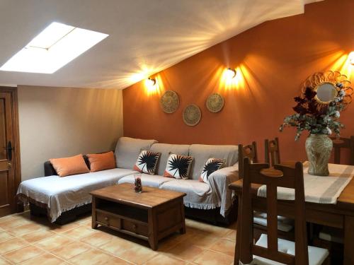 una sala de estar con un sofá y una mesa en El Ático de Lola, en El Bosque