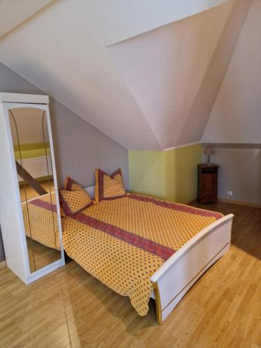 une chambre avec un lit et un miroir dans l'établissement Appartement à l étage d une maison en pleine campagne, à Métairies-Saint-Quirin