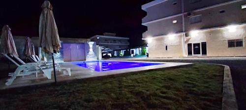 una piscina por la noche con sombrilla y silla en Hotel Cuesta de Miranda II en Villa Unión