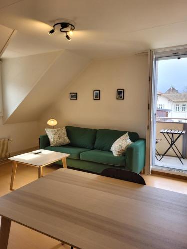 a living room with a green couch and a table at Interlaken Apartments in Interlaken