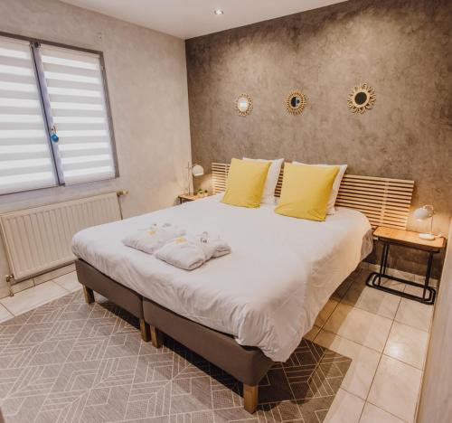 ein Schlafzimmer mit einem großen Bett mit gelben Kissen in der Unterkunft La Loupiote - Gîte éclairé 