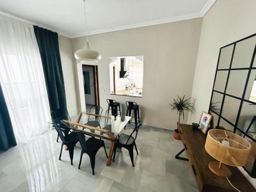 a dining room with a glass table and chairs at La Casa de Carmen in Castilleja de la Cuesta