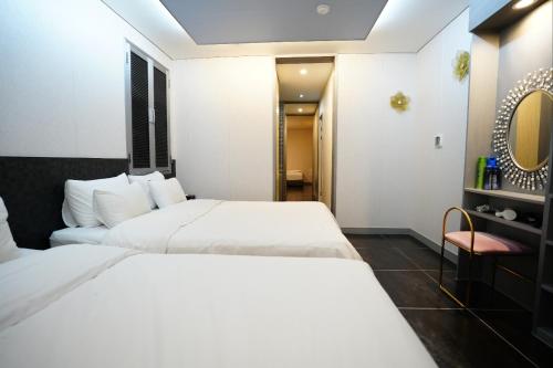 une chambre d'hôtel avec deux lits et une chaise dans l'établissement Shinchon Y Hotel, à Séoul