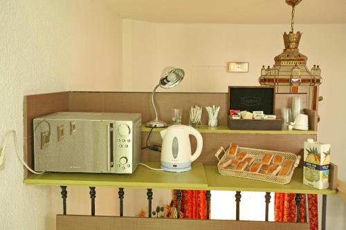 eine Theke mit einer Mikrowelle auf einem Regal in der Unterkunft Pension Zurita in Granada
