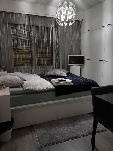 a bedroom with a large bed and a chandelier at Private Room next to Helsinki-Vantaa Airport in Vantaa