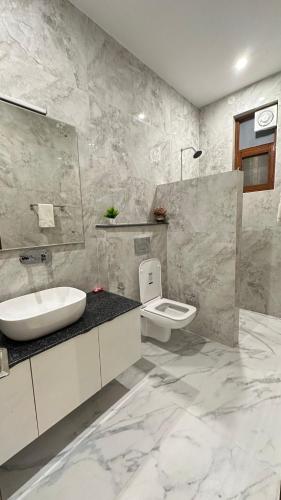 a white bathroom with a sink and a toilet at Fourseasonkasauli in Solan