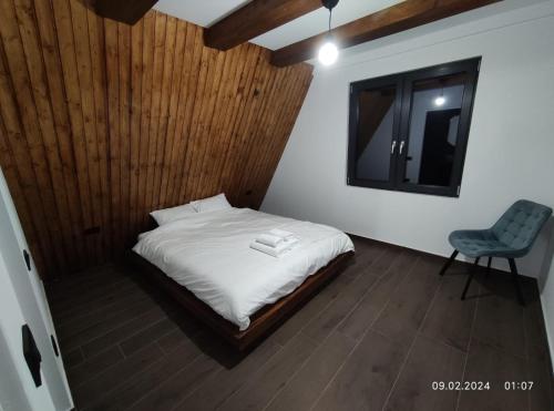 een slaapkamer met een bed met een stoel en een spiegel bij Cabana NucA-Frame in Satu Nou de Jos