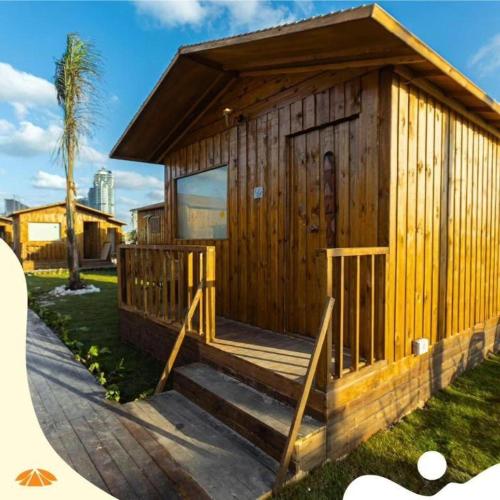 - un petit bâtiment en bois avec une terrasse couverte et des marches dans l'établissement Safy Bay Resort, à El Alamein