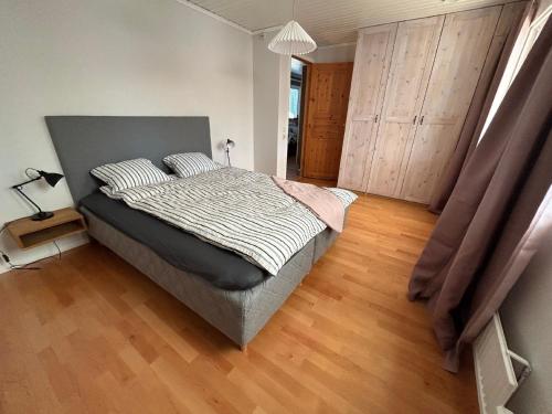 - une chambre avec un grand lit et du parquet dans l'établissement Schönes Großes Haus Oskarshamn, à Oskarshamn
