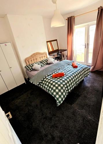 a bedroom with a bed with orange pillows on it at Wolves Living in Bushbury