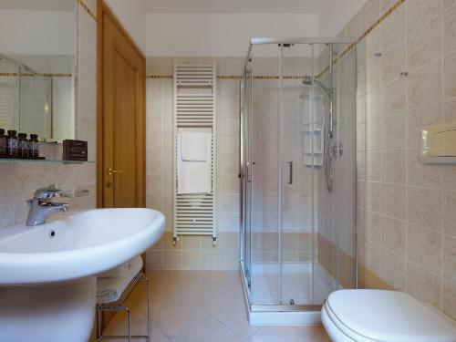 a bathroom with a shower and a sink and a toilet at Residence Besass, GTSGroup in Tignale