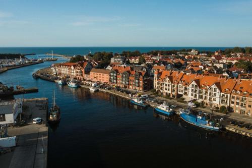 an aerial view of a city with boats in the water at Apartamenty Bałtyckie - Grand Baltic - WIFI, Klimatyzacja, Sala Zabaw, Taras wypoczynkowy, centrum Ustki in Ustka