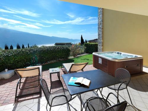 a patio with a table and chairs and a hot tub at Residence Besass, GTSGroup in Tignale