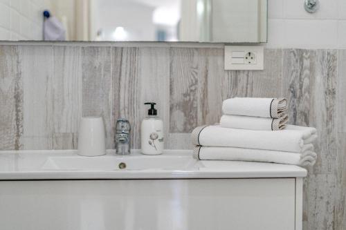 a bathroom with a sink and a pile of towels at BuenaVista Romantic Bungalow in Costa Adeje in Adeje