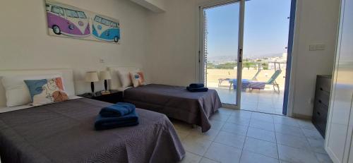 1 dormitorio con 2 camas y vistas a un patio en Romanson Seaview Apartment, en Kissonerga