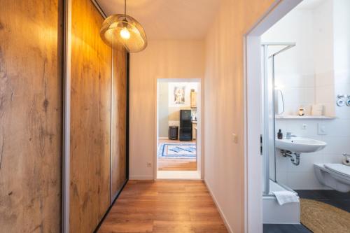 a hallway with a bathroom with a sink and a mirror at Design Apartments - "Am Schloss" in Potsdam