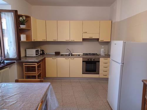 a kitchen with white appliances and a white refrigerator at Appartamento A 2 passi dal Lago Idro Lake in Bondone