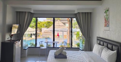 a bedroom with a bed and a view of a pool at Siri Maya Garden Home Samui in Koh Samui 