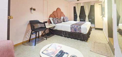 a bedroom with a bed and a desk with a laptop at Hotel Nova Bling in Rajkot