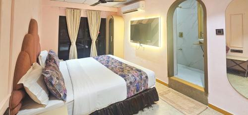 a bedroom with a bed and a walk in shower at Hotel Nova Bling in Rajkot