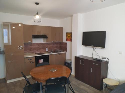 eine kleine Küche mit einem Tisch und einem TV in der Unterkunft Studio proche de la gare et du centre ville in Châlons-en-Champagne