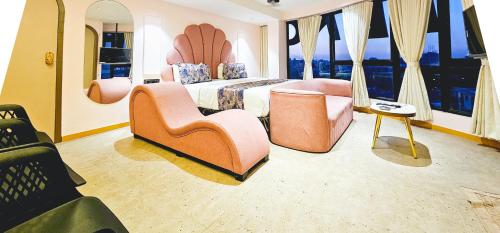 a hotel room with a bed and chairs and windows at Hotel Nova Bling in Rajkot