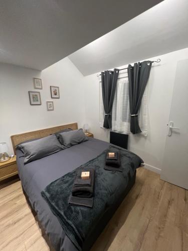 - une chambre avec un grand lit et des rideaux noirs dans l'établissement L’escale proche paris, à Maisons-Alfort